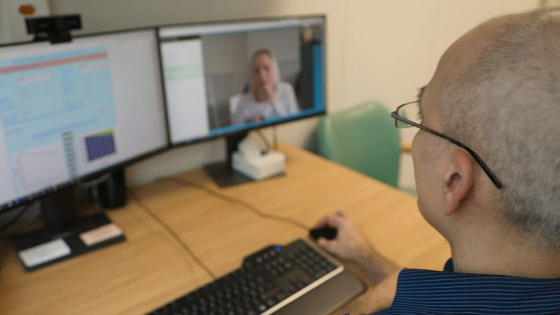 A doctor using video conferencing software to see a patient